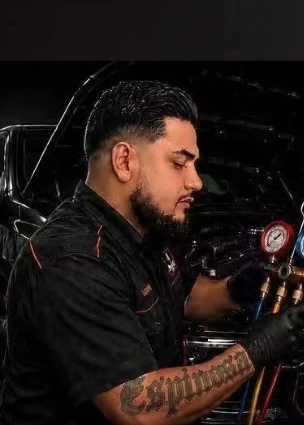 Mechanic servicing an automotive air conditioning system